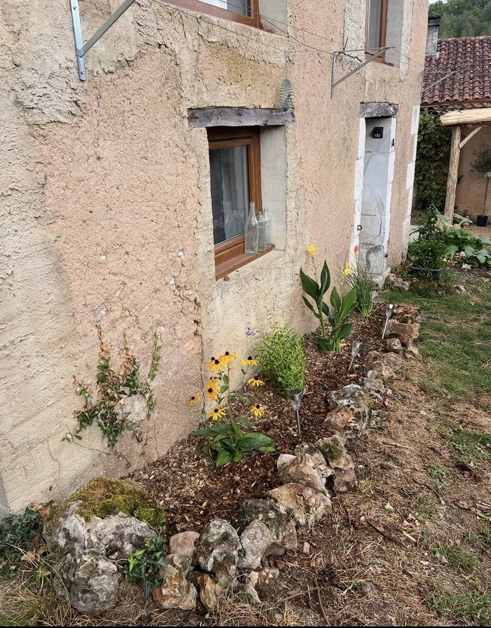 Après : façade désherbée avec massif de fleurs planté
